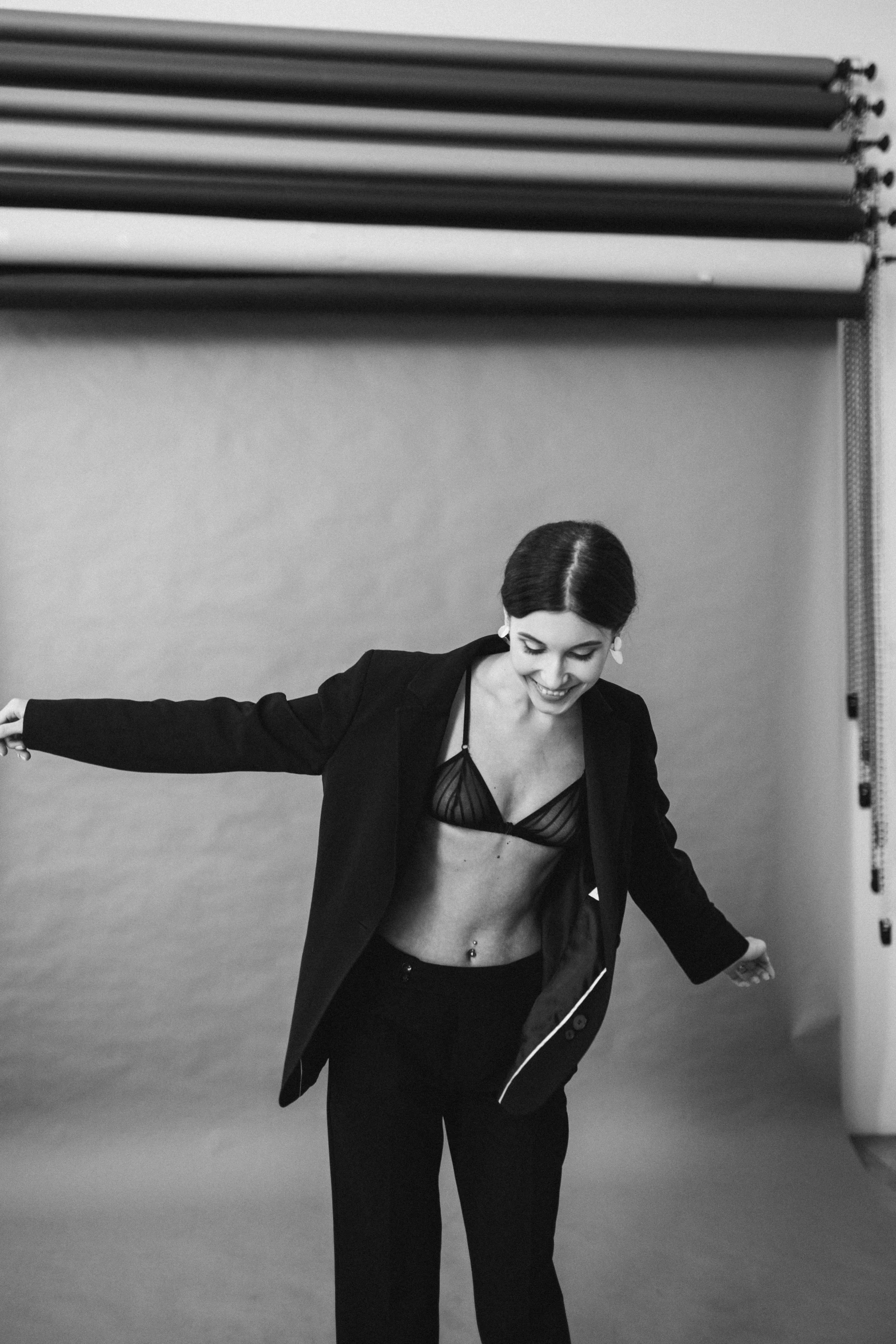 a woman in lingerie and blazer on a skateboard