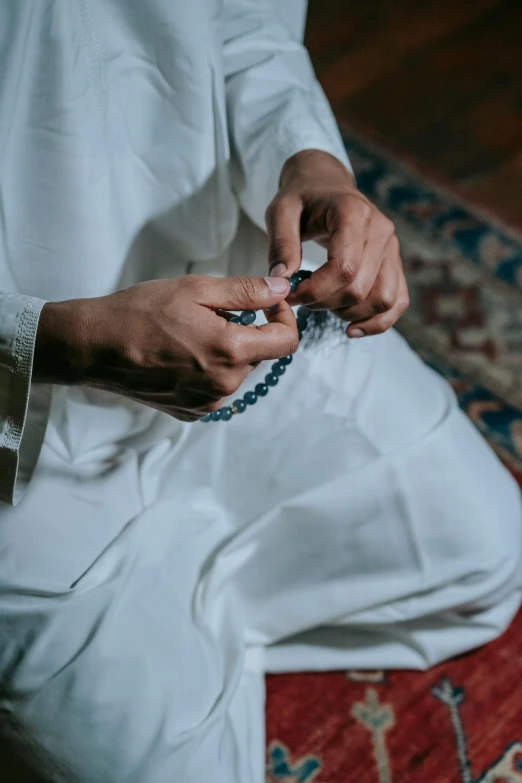 a person sitting on top of a rug  string