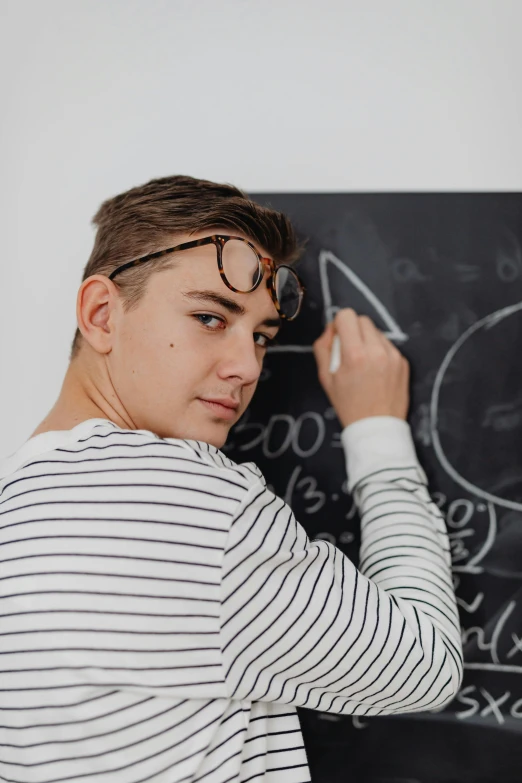 a man writing on a blackboard next to another man
