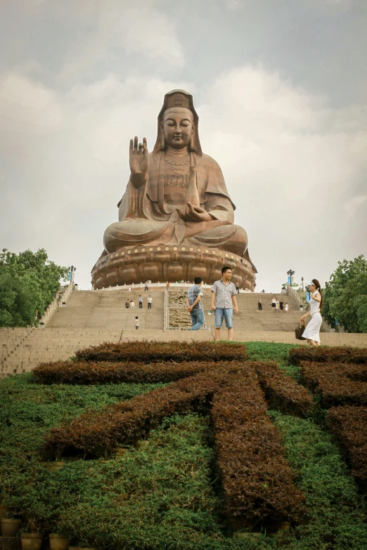 two people standing in front of a giant statue