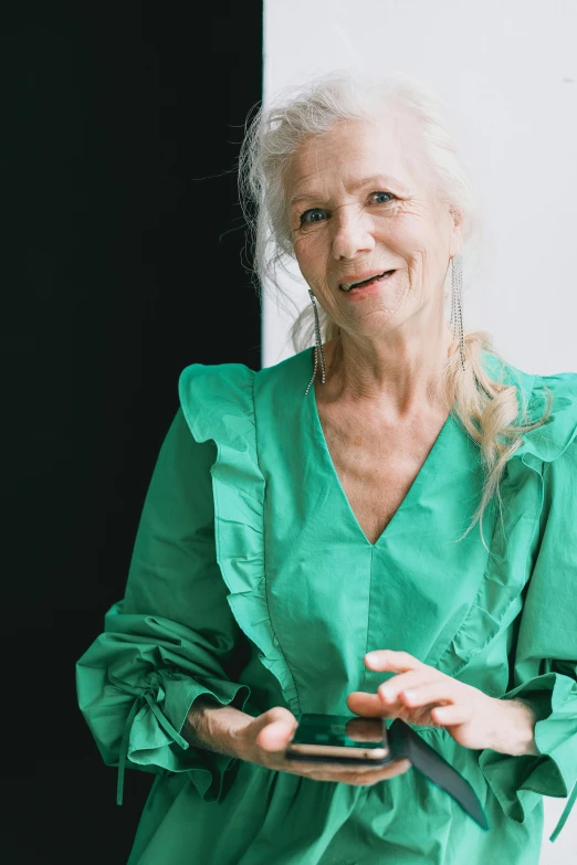 an older woman wearing a green top is holding a plate