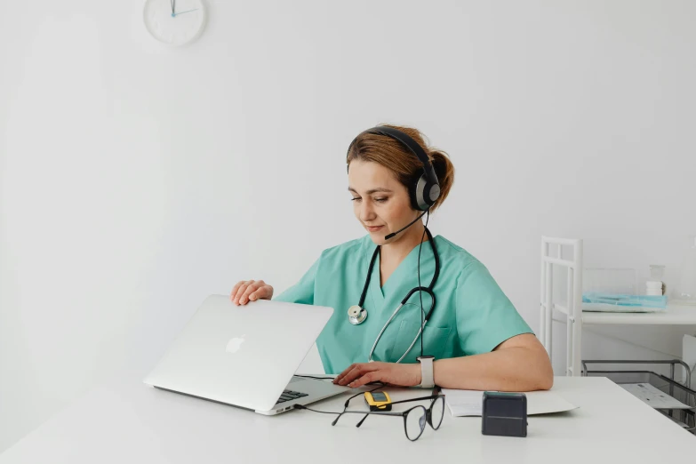 a female in a nurse costume sitting at a desk with a laptop