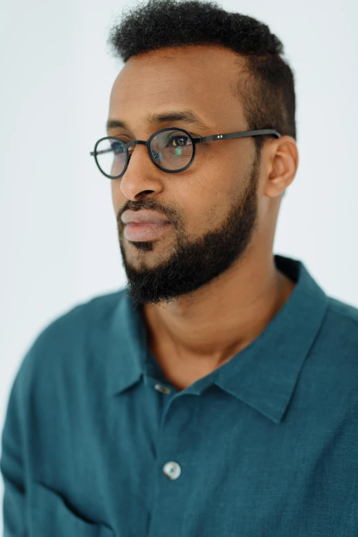 a black man wearing a blue shirt and glasses