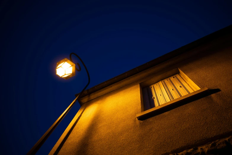 a lamp shines outside of an old building