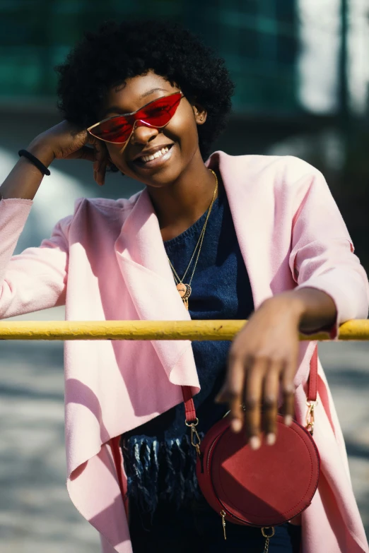 the woman is wearing sunglasses and posing with a bag