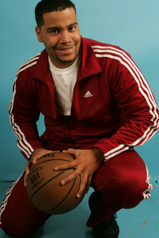 a man holding a basketball in front of a blue background