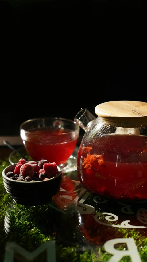 a pitcher and bowl filled with raspberry drink on a table