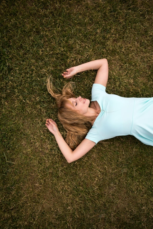 a woman laying on the ground with her hair in a ponytail