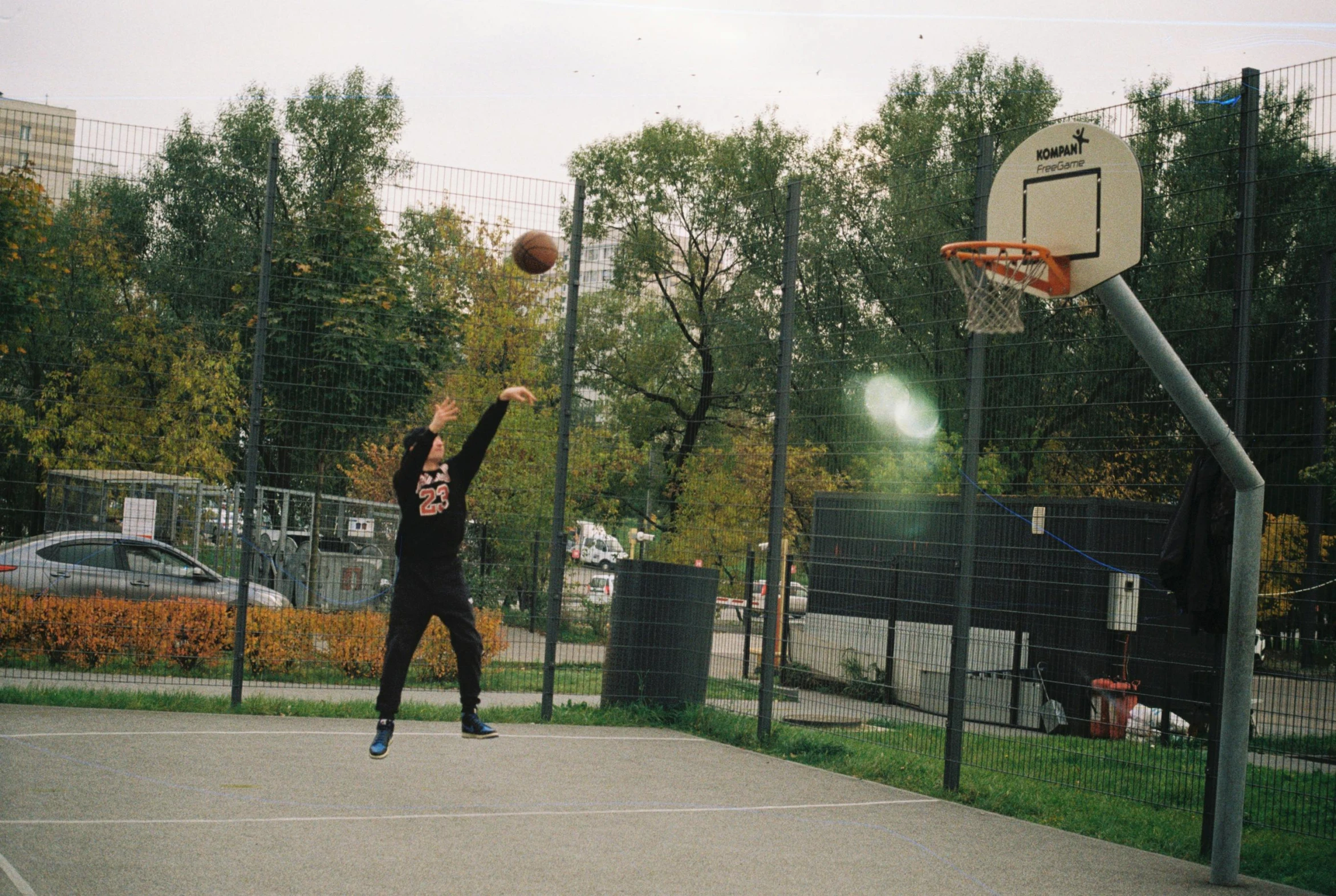 a young man playing with a basketball in the park