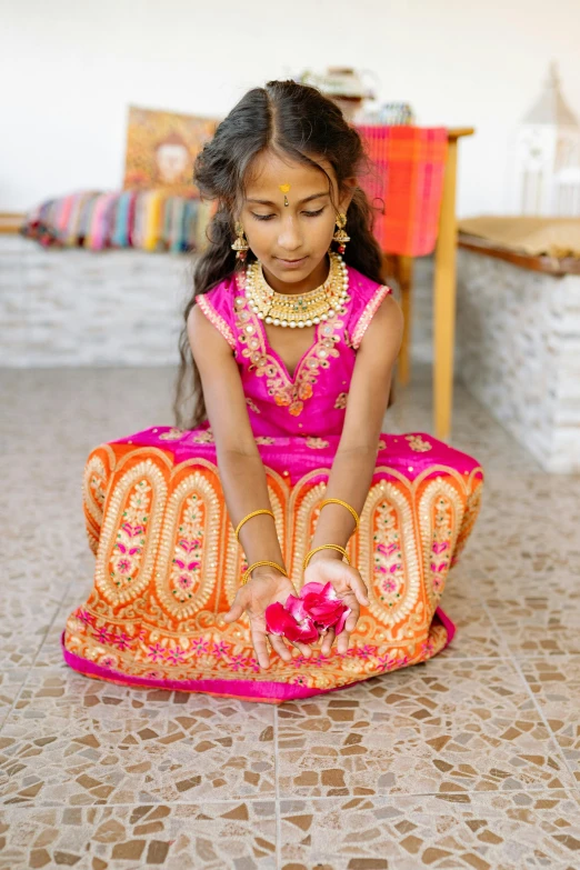 the girl is tying up her pink sari