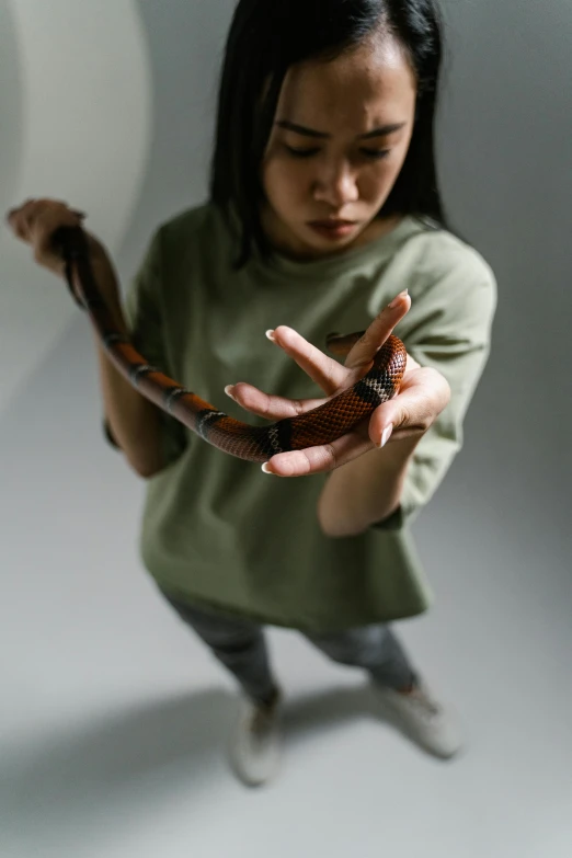 a woman is holding a snake and showing it to the camera