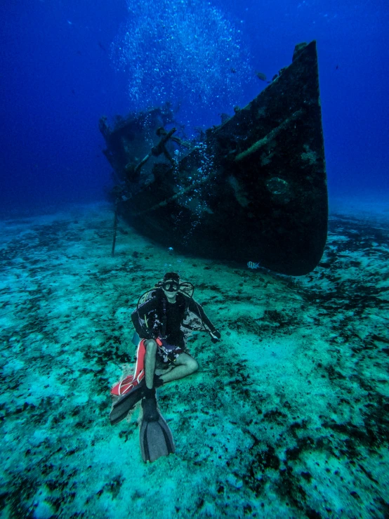 an underwater scubas in front of a boat wreck in the ocean