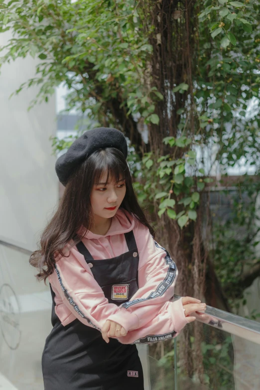 an asian girl wearing a black hat and pink jacket