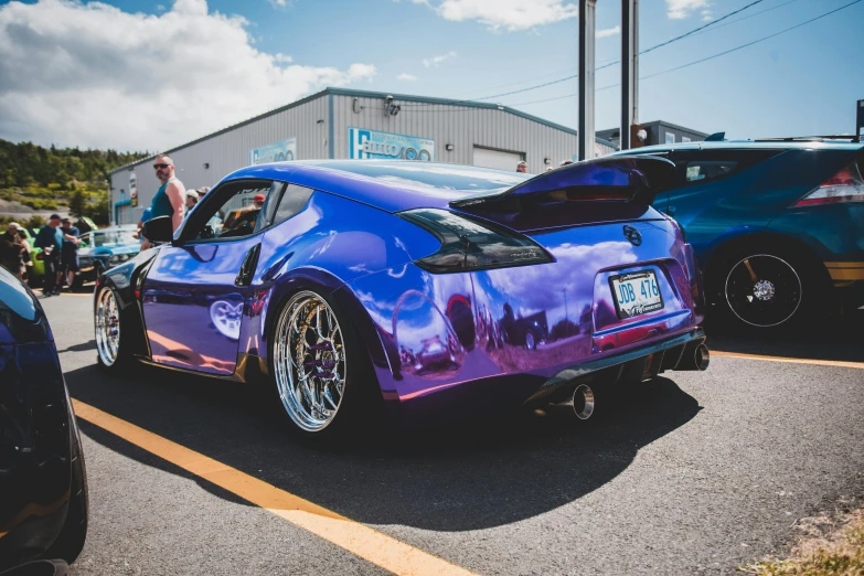 a purple car parked in a lot next to other cars