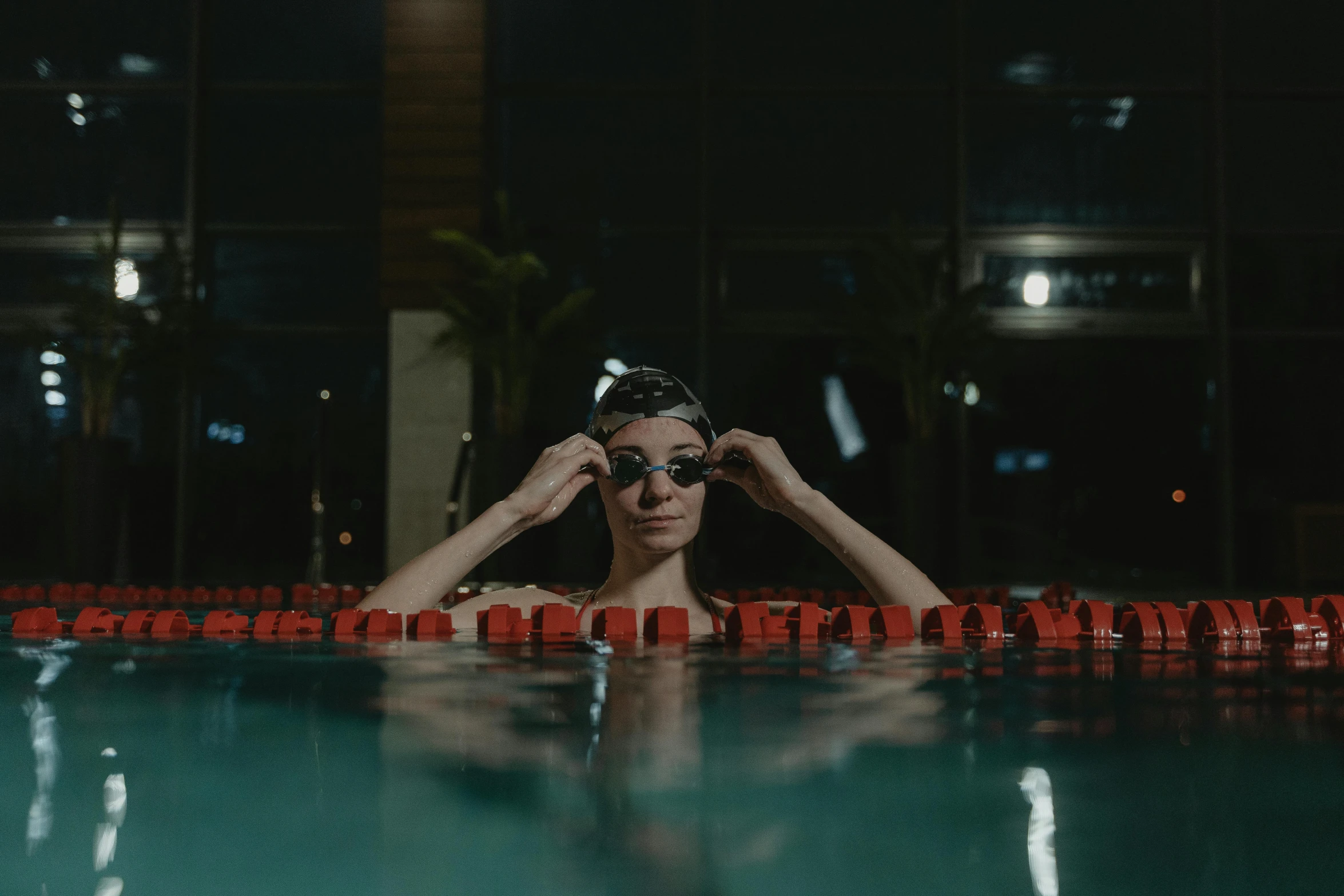 a man in a swimming cap and goggles standing in a pool