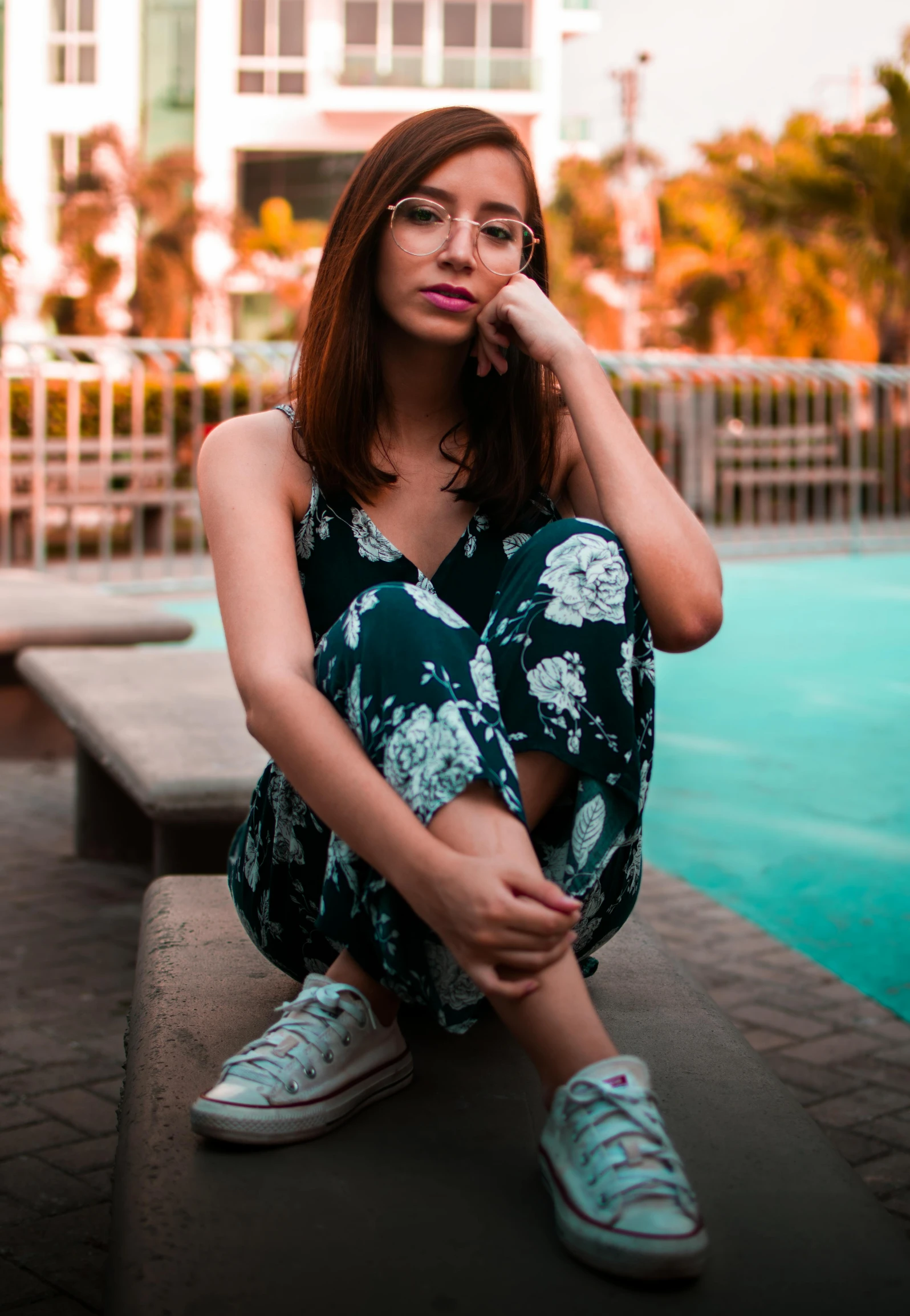 a beautiful woman sitting next to a pool