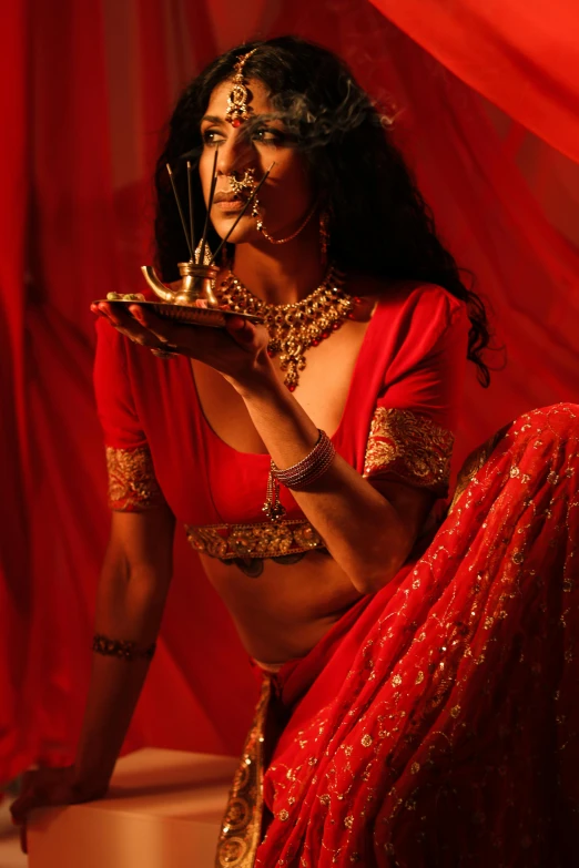 the woman dressed in a red outfit poses with an ornate tray