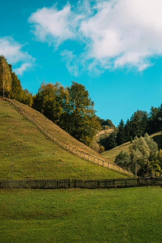 a wooden fence in the middle of a green field