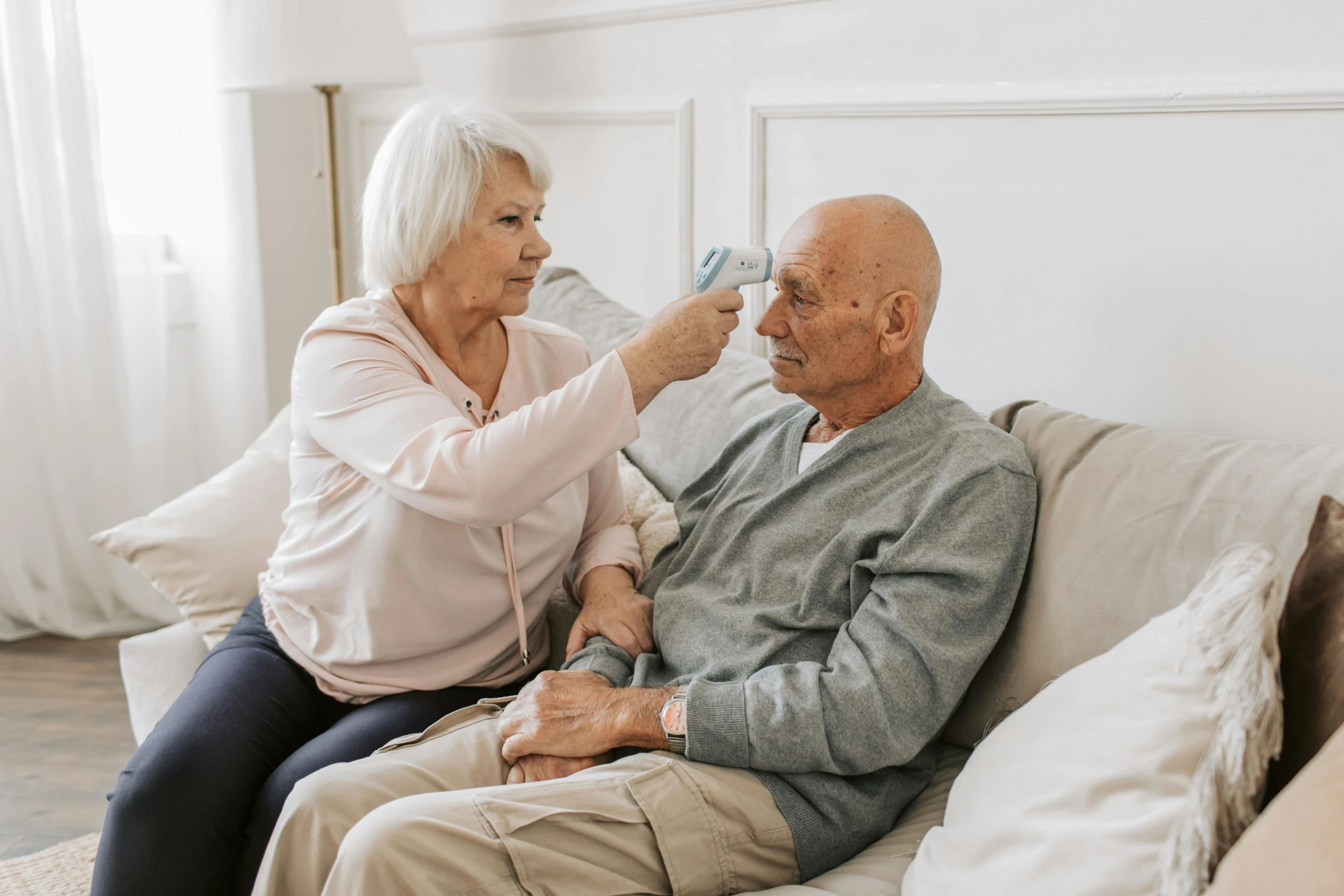 a woman is drying an older man's hair with an electric razor