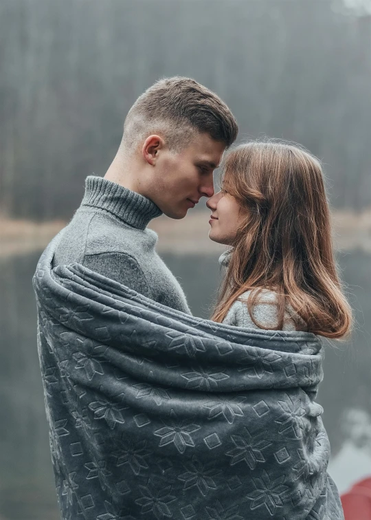 a man and a woman are wrapped in blankets