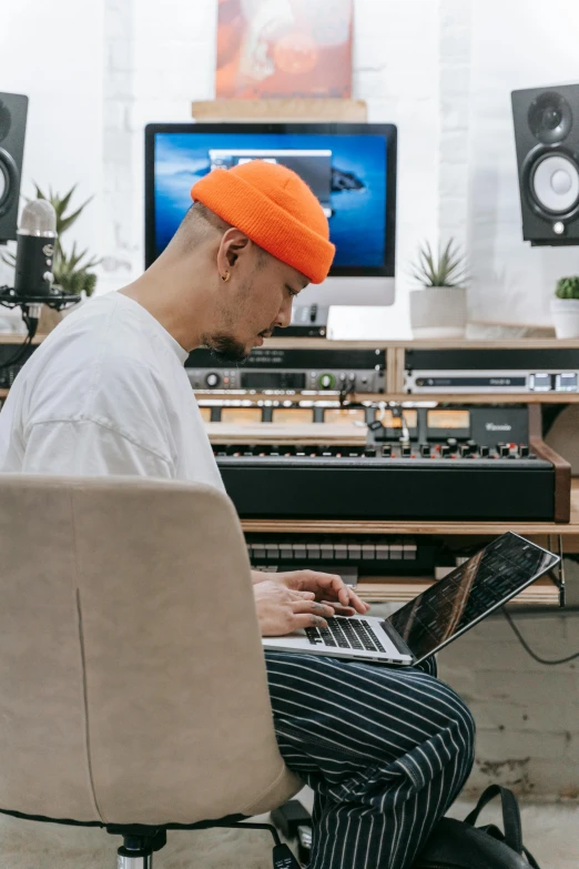 a man with an orange headband is playing on his laptop