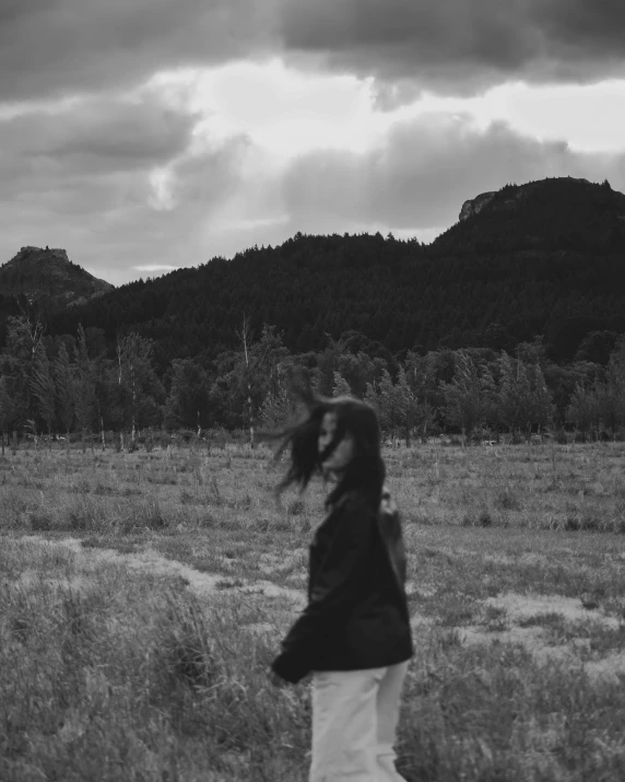 a woman in the field looks at soing while she stands