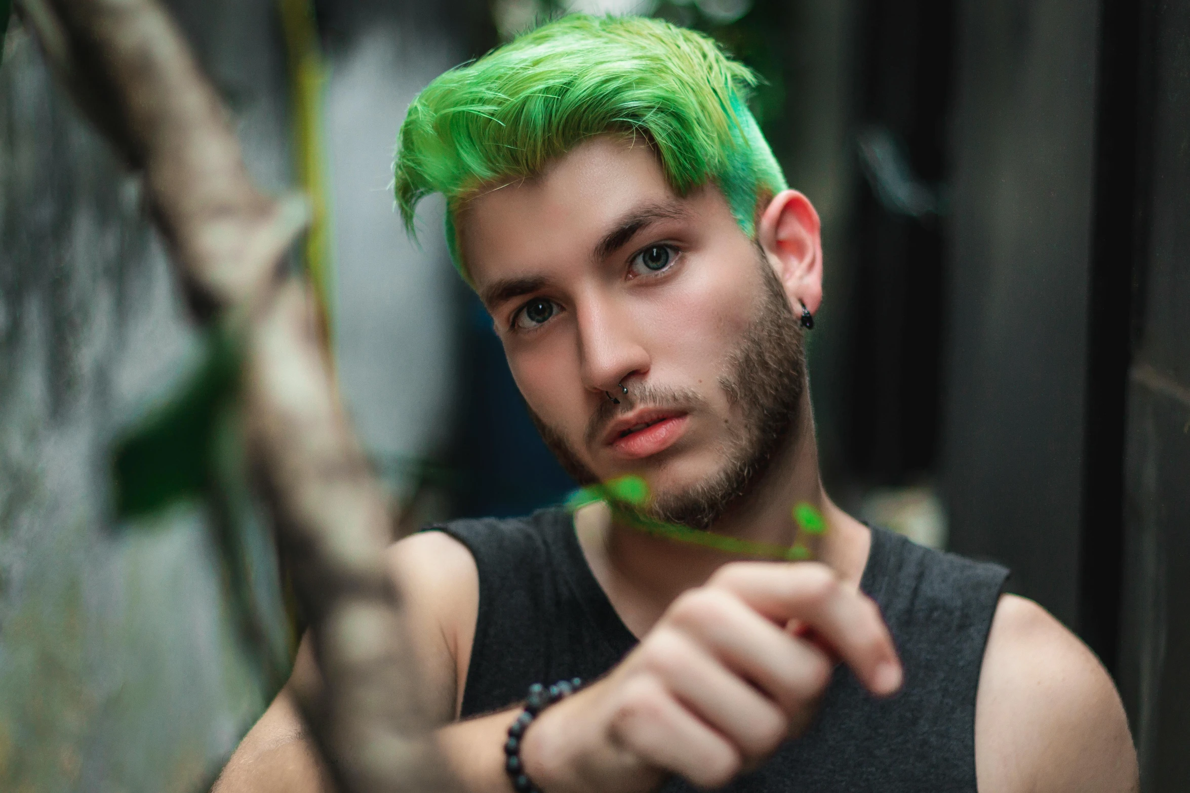 a man with green hair pointing at soing