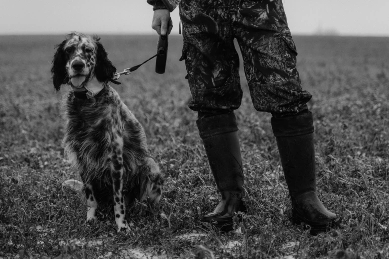 a soldier is holding his rifle while standing with his dog