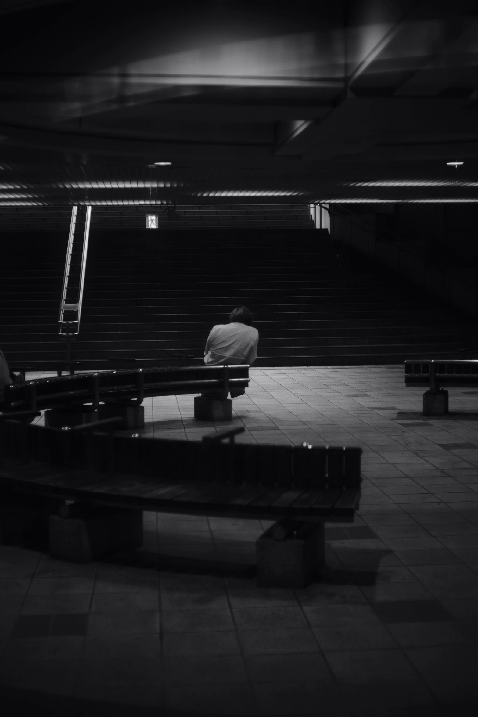 two people sitting on benches in the dark