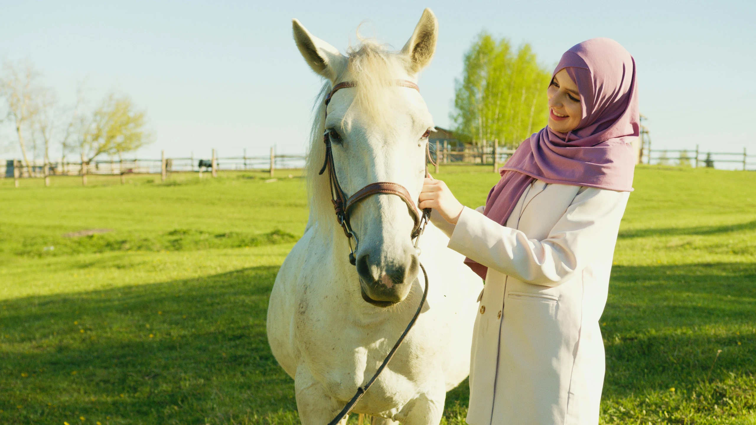 a woman is standing with a white horse