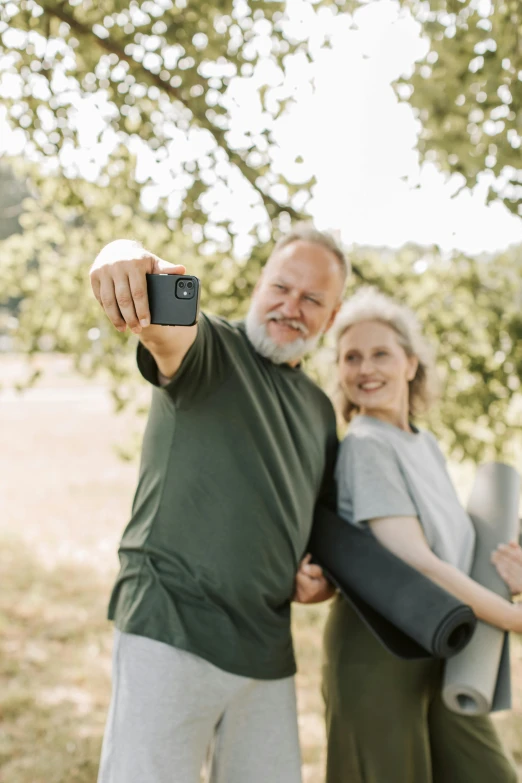 a man and woman holding up a small camera