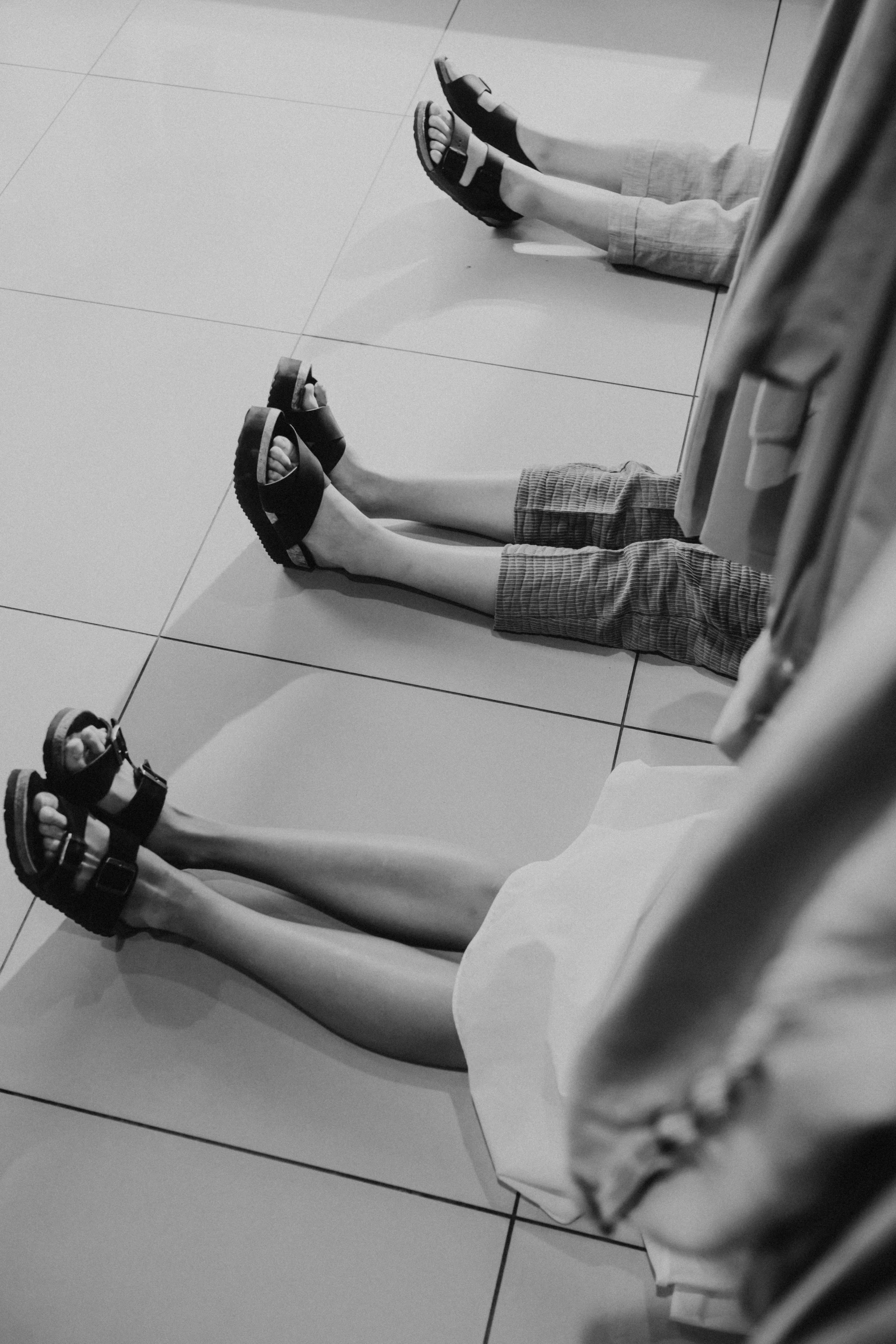 young men sitting on the floor wearing various shoes