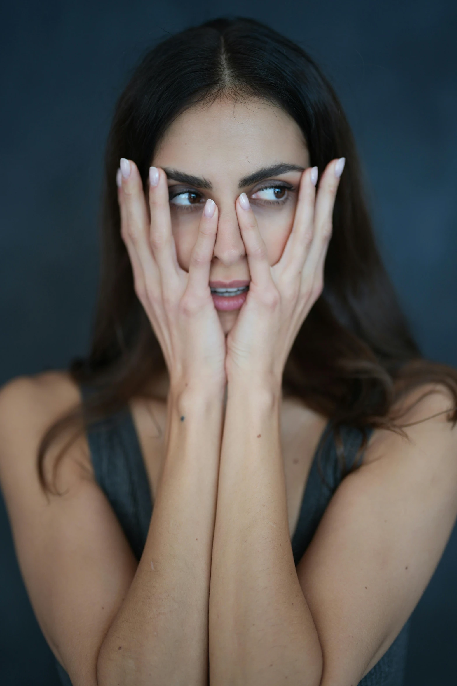 a woman covering her face with both hands