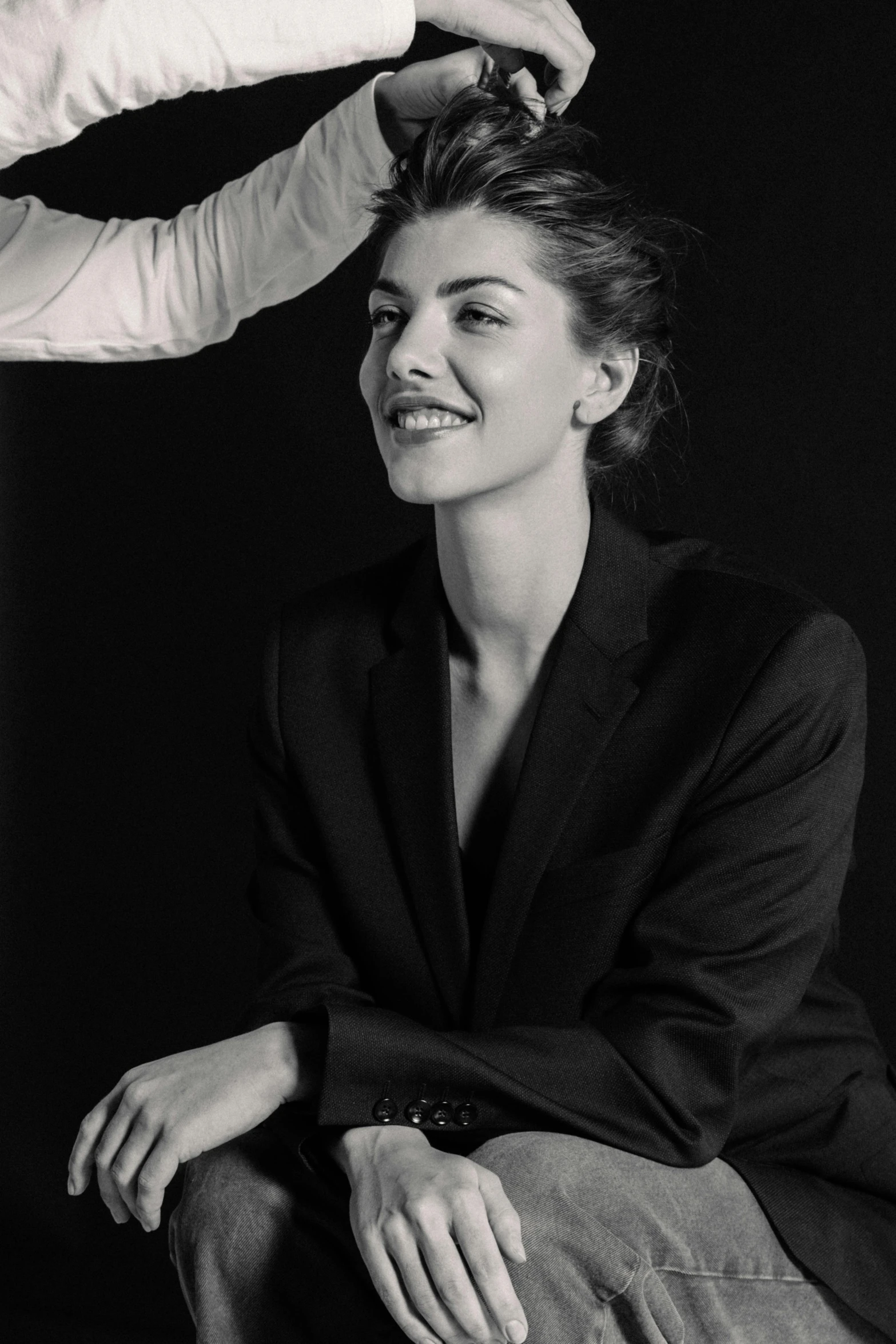 a woman is sitting down with her hair in a ponytail