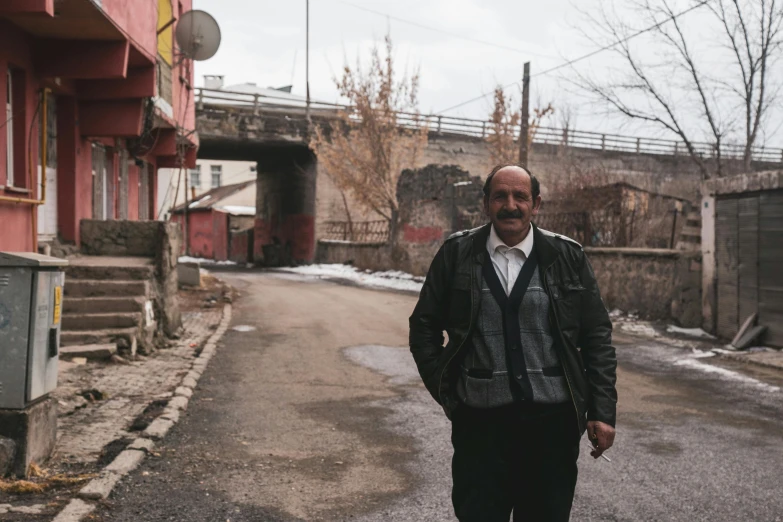 a man standing on the road in front of some buildings