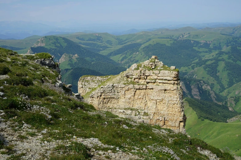 a rocky mountain in a green valley