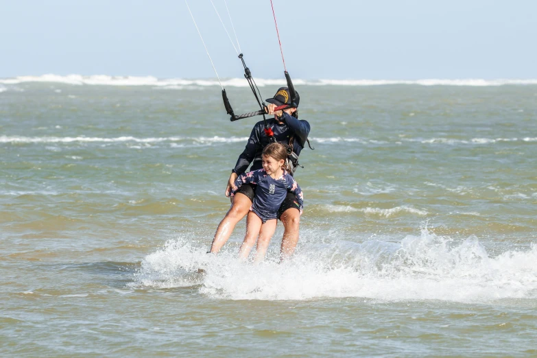 some people water surfing and one is on a surf board