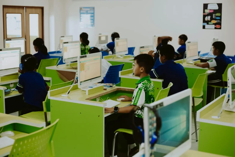 a classroom with children using computers and laptops