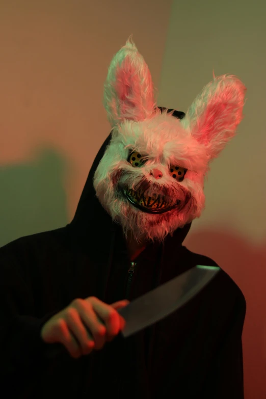 a man with bunny ears and makeup on holding a knife