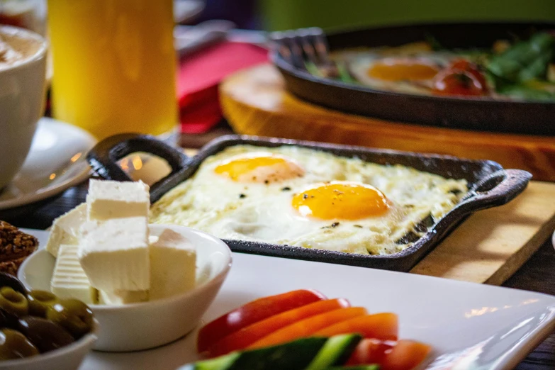 an egg, cheese and tomatoes are sitting on the table