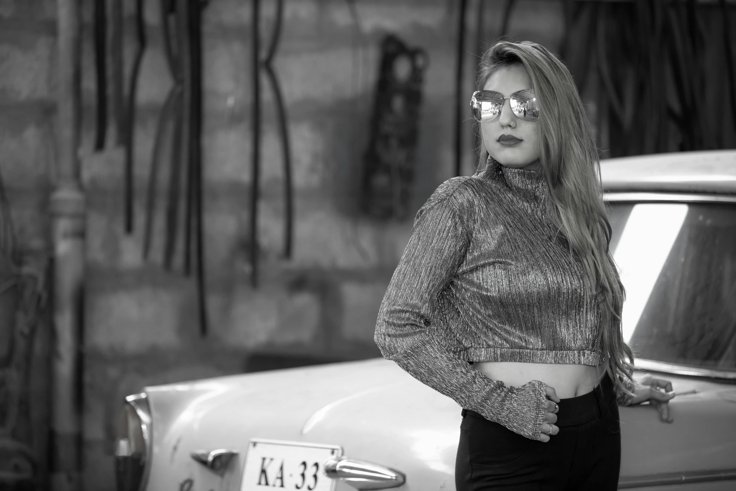 a woman with long hair is standing by a car