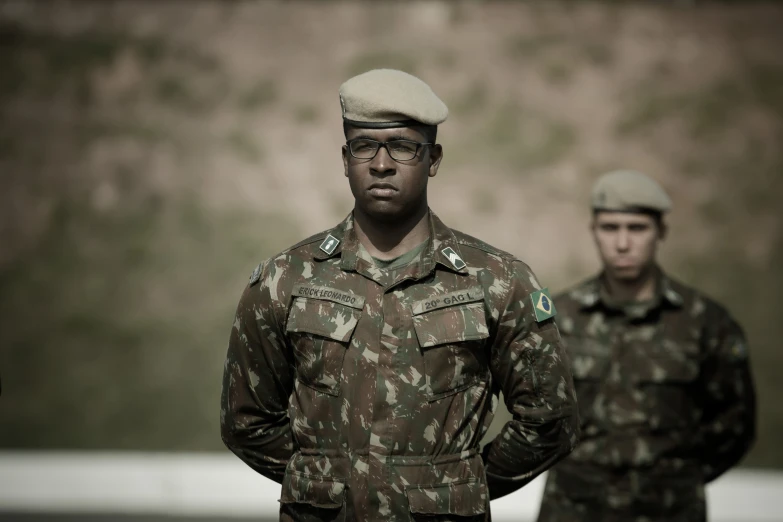 two men in military uniforms are looking at the camera