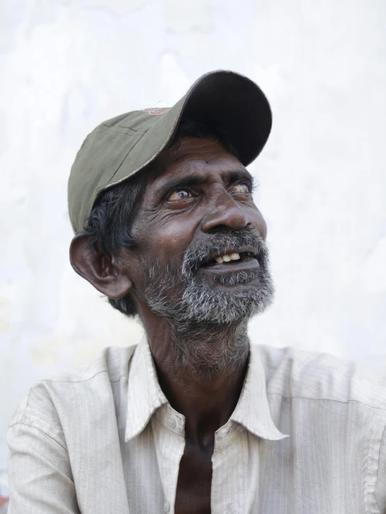 man in dress cap looking up and laughing