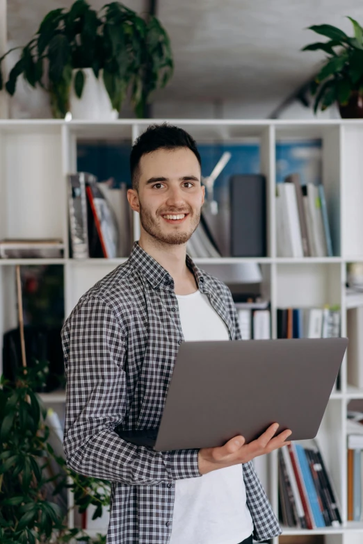 a young man is holding a binder and smiling