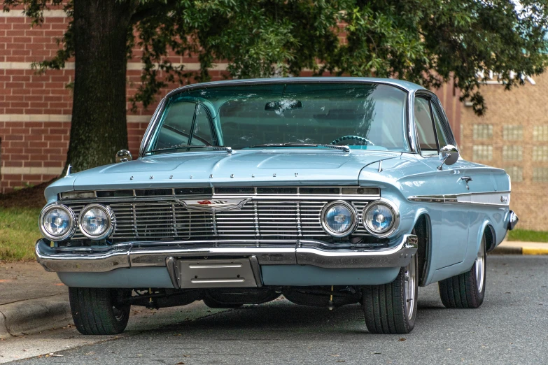 a blue classic vehicle parked on a street