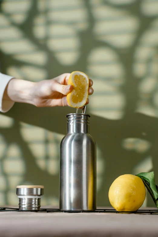 the person is removing the sliced lemon from the bottle