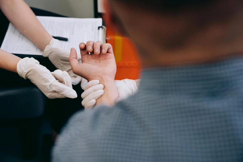 hands in white gloves are doing soing with the help of a nurse