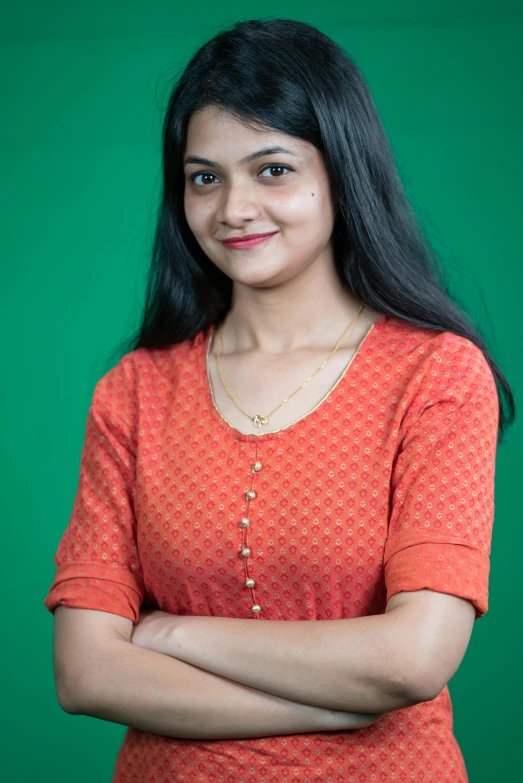 a beautiful young lady standing in front of green background