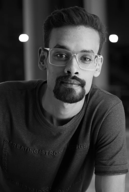 black and white po of a man with glasses looking straight ahead