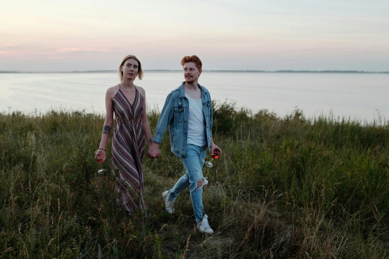 two people walking near water holding hands